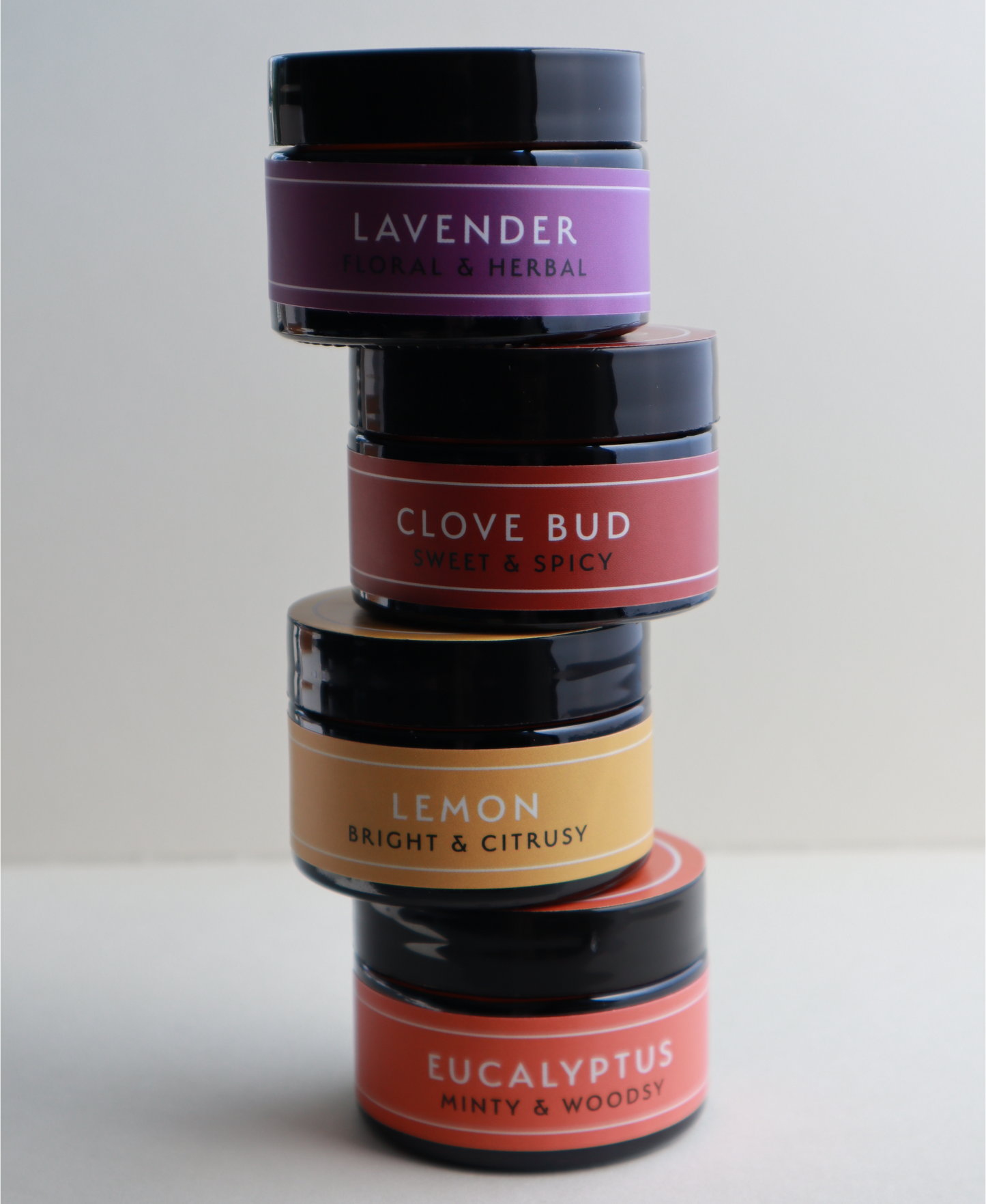The Olfactory Training Kit: four essential oil jars stacked vertically showing the amber glass packaging.