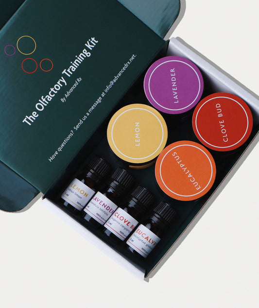 The Olfactory Training Kit: pharmacy-assembled smell training kit with four GC/MS-verified essential oils (lavender, lemon, clove bud, eucalyptus) in amber glass bottles, made at Advanced Rx, a licensed compounding pharmacy.